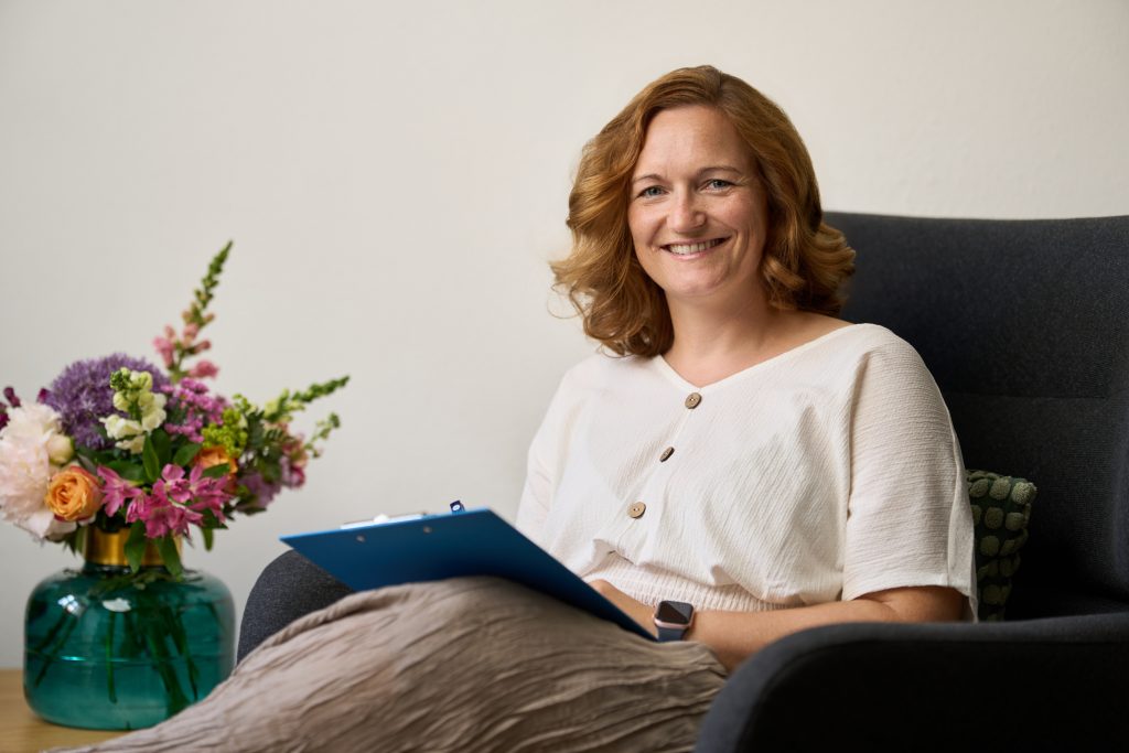 lächelnde weibliche Person sitzende im Sessel