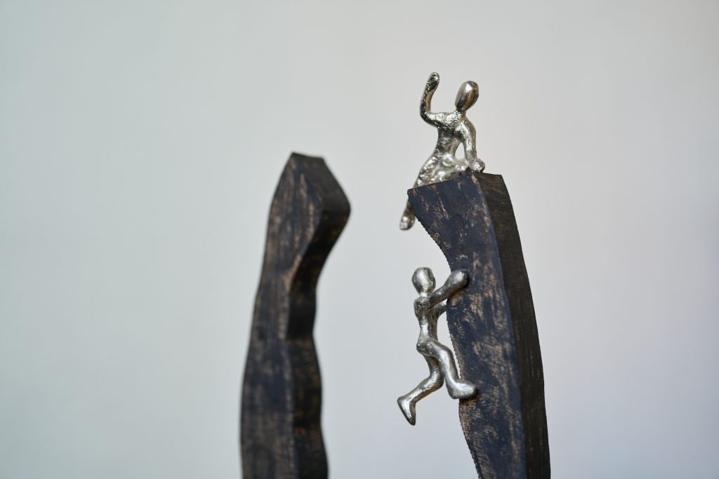 Skulptur mit kletternden Menschen