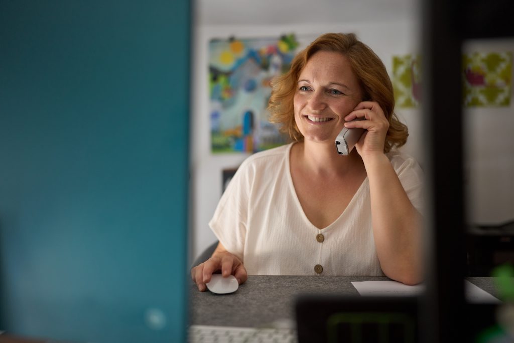 lächelnde beratende weibliche Person am Computer