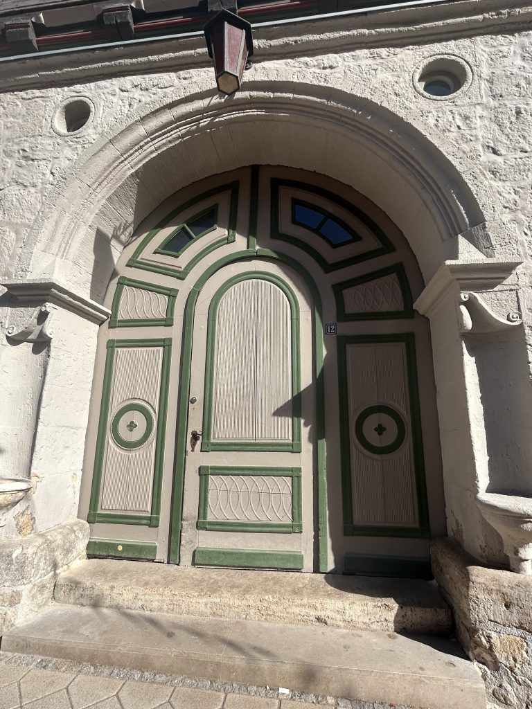 grosses Holztor mit grünen Ornamenten